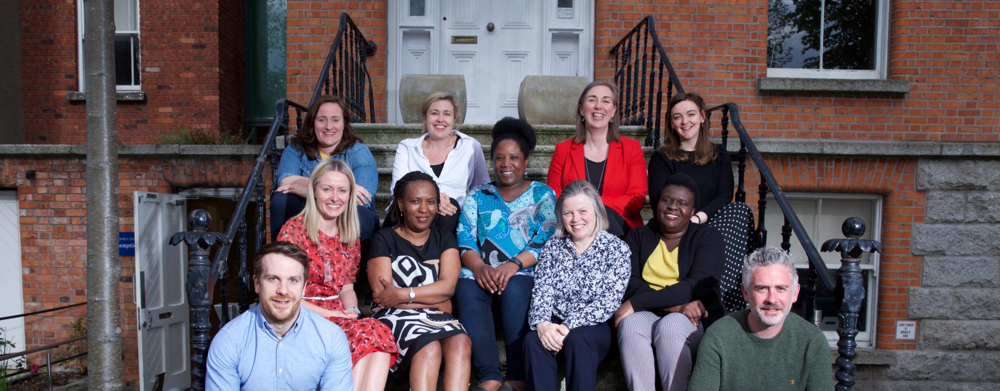 MS Ireland staff sitting on the steps outside the National Office, smiling and posing for a group photo