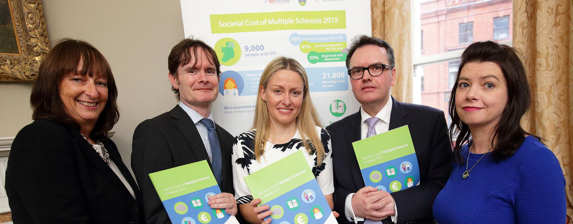 Five people standing together, each holding a copy of the new 'Societal Cost of MS' booklet