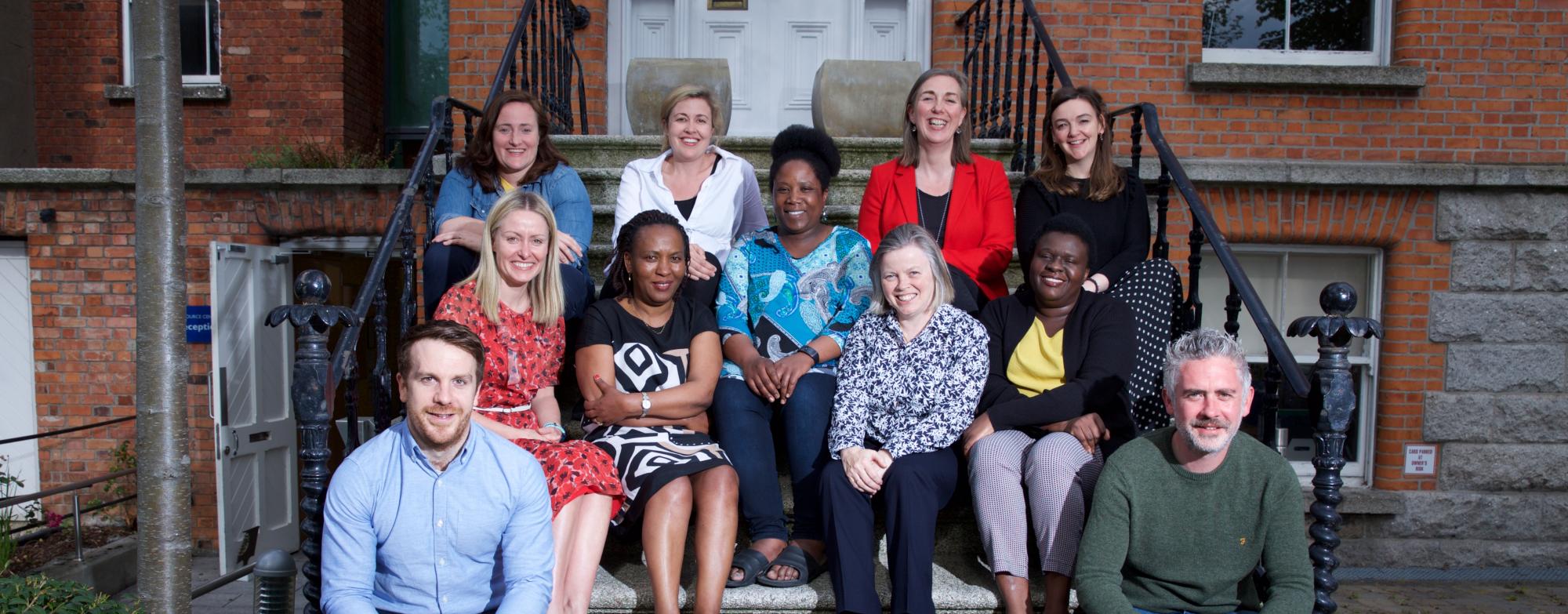 MS Ireland staff sitting on the steps outside the National Office, smiling and posing for a group photo