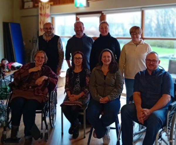 Group photo of participants from the MS Fatigue Management Programme, with some standing in the back and others seated in the front row, taken in a bright room with a large window.