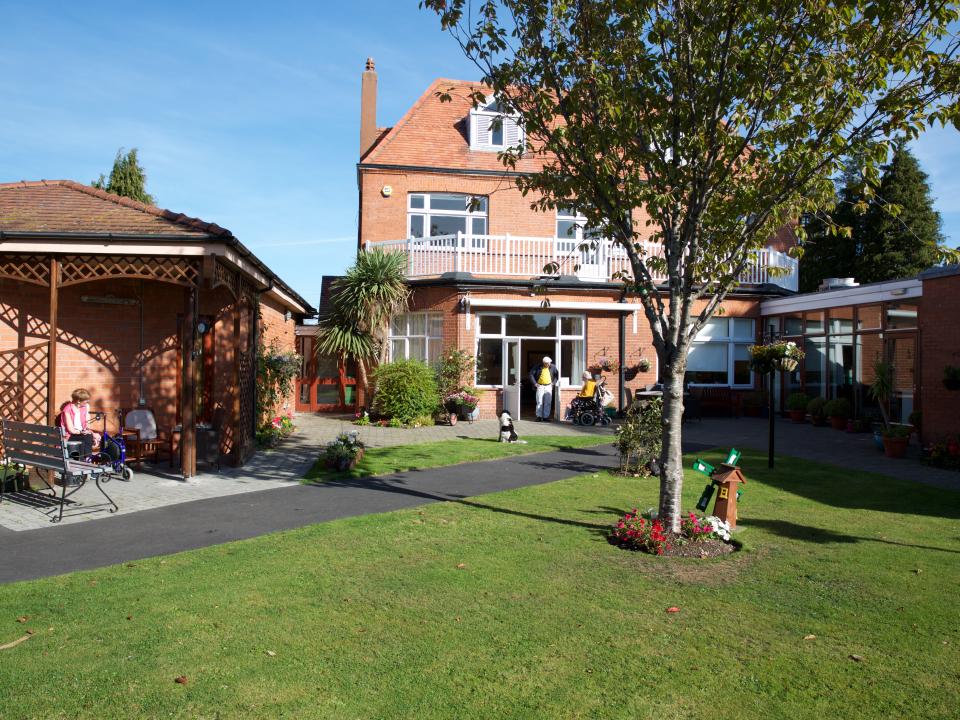 MS Care Centre building with a garden and trees, offering a peaceful outdoor space