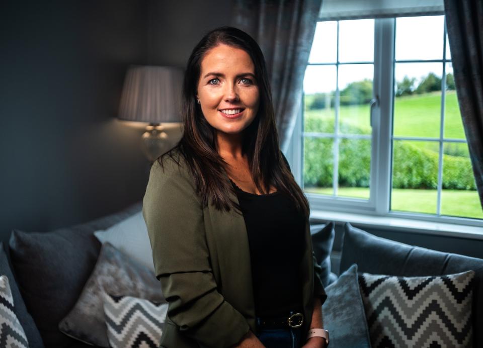 Person smiling standing by a window