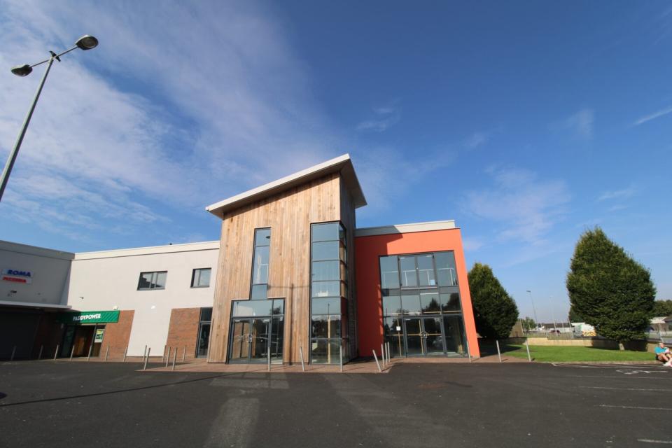 Clear blue sky above the new MS Resource Centre in Limerick, with a tall tree in the foreground